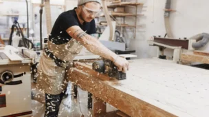 um homem trabalhando em uma marcenaria